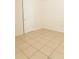 Simple bedroom with tile floors and a door at 7131 Coventry Dr, Port Richey, FL 34668