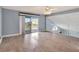 Living room with wood-look floors, balcony access and ceiling fan at 741 Fairway Ridge Ct, Sun City Center, FL 33573