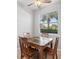 Small dining area with wood table and four chairs near a window at 8003 Limestone Ln # 15-103, Sarasota, FL 34233