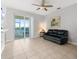 Living room with sliding doors to patio and a black leather couch at 8003 Limestone Ln # 15-103, Sarasota, FL 34233
