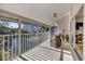 Spacious screened balcony overlooking a pond with comfortable wicker furniture at 1130 W Peppertree Ln # 118, Sarasota, FL 34242