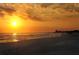 Orange and yellow sunset over the ocean and beach at 1130 W Peppertree Ln # 118, Sarasota, FL 34242