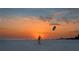 Stunning sunset over the beach with a person flying a kite at 1130 W Peppertree Ln # 118, Sarasota, FL 34242