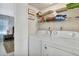 Convenient laundry room with washer, dryer, and storage shelves at 1130 W Peppertree Ln # 118, Sarasota, FL 34242