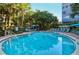 Relaxing kidney-shaped pool surrounded by lush landscaping at 1130 W Peppertree Ln # 118, Sarasota, FL 34242