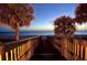Illuminated wooden walkway leading to the beach and ocean during the early evening at 1800 Benjamin Franklin Dr # A405, Sarasota, FL 34236