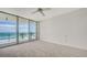 Bright bedroom with a ceiling fan and a large sliding glass door to a beachfront balcony at 1800 Benjamin Franklin Dr # A405, Sarasota, FL 34236