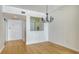 Open dining area with wood floors, chandelier, and access to entry and kitchen at 1800 Benjamin Franklin Dr # A405, Sarasota, FL 34236