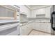 Well-equipped kitchen with white appliances and cabinetry, offering a functional layout at 1800 Benjamin Franklin Dr # A405, Sarasota, FL 34236