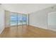 Inviting living room showcasing wood floors and access to a balcony overlooking the ocean at 1800 Benjamin Franklin Dr # A405, Sarasota, FL 34236