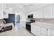 White kitchen with granite countertops and stainless appliances, next to a dining area at 2271 Sandlewood Dr, Venice, FL 34293