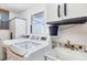 Well-equipped laundry room, includes modern washer, dryer, utility sink and storage at 2271 Sandlewood Dr, Venice, FL 34293