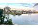 Picturesque water view of homes across the lake, set against a colorful evening sky at 2271 Sandlewood Dr, Venice, FL 34293