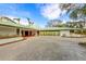 Mid-century modern home with circular driveway and green roof at 245 Willow Ave, Anna Maria, FL 34216