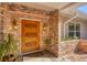 Close up of the front door with decorative lamps, brick accents, and a welcome mat at 2605 Desoto Rd, Sarasota, FL 34234