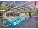 Covered pool area with a screened enclosure, providing a cool and shaded retreat for relaxation and recreation at 2605 Desoto Rd, Sarasota, FL 34234