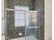 Shower with glass doors, patterned tile and chrome hardware at 2605 Desoto Rd, Sarasota, FL 34234