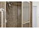 Close-up of a tiled shower with a shower head and safety bar, enclosed by a glass door at 2605 Desoto Rd, Sarasota, FL 34234