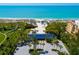 Aerial view of a beach with blue canopies, palm trees, and a building with a blue roof at 3260 Bayou Rd, Longboat Key, FL 34228