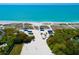 Aerial view of beach featuring white sand, blue canopies, volleyball net and clear turquoise water at 3260 Bayou Rd, Longboat Key, FL 34228
