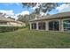 Back of house with a large, grassy yard and screened enclosure at 3379 Hadfield Greene # 56, Sarasota, FL 34235