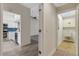 Hallway view into kitchen with white cabinetry, stainless steel appliances, and blue backsplash, laundry is located to the right at 5436 Hampstead Heath # 25, Sarasota, FL 34235