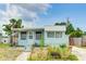 Light teal single-wide mobile home with porch and landscaped yard at 604 49Th Avenue W Dr, Bradenton, FL 34207