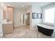 Chic bathroom with soaking tub, glass shower, light wood vanity and herringbone tile flooring at 1541 Bay Point Dr, Sarasota, FL 34236