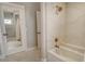Bright bathroom featuring a white tub, marble tile, and a shower with bronze fixtures at 1541 Bay Point Dr, Sarasota, FL 34236