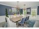 Elegant dining room with blue walls, modern lighting, and seating for eight at 1541 Bay Point Dr, Sarasota, FL 34236