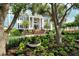 Stately two-story home with classic architecture, blue shutters, mature trees, and meticulously landscaped front yard at 1541 Bay Point Dr, Sarasota, FL 34236