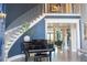 Spacious foyer with a curved staircase, piano, and high ceilings, creating a grand entrance at 1541 Bay Point Dr, Sarasota, FL 34236