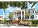 Stately home with a brick staircase, white columns, blue shutters, and manicured landscaping at 1541 Bay Point Dr, Sarasota, FL 34236