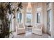 Inviting seating area featuring neutral armchairs, chandelier, and scenic water views at 1541 Bay Point Dr, Sarasota, FL 34236