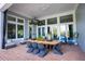 Covered patio with brick flooring, a dining table, comfortable seating, and large windows at 1541 Bay Point Dr, Sarasota, FL 34236