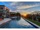 Luxury home featuring a long pool, manicured lawn, and sunset views on the water at 1541 Bay Point Dr, Sarasota, FL 34236