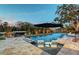 Tranquil pool area with lounge chairs, fire feature, and lush greenery, creating a serene outdoor oasis at 1541 Bay Point Dr, Sarasota, FL 34236