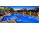 Luxury home with pool, spa, landscape lighting, outdoor furniture, and mature palm trees at twilight at 1541 Bay Point Dr, Sarasota, FL 34236