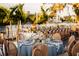 Elegant table setting with blue linens, patterned plates, fine glassware, and floral centerpiece near waterfront at 1541 Bay Point Dr, Sarasota, FL 34236