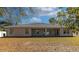 View of the back of the house featuring a covered patio and large windows overlooking the yard at 2155 Jagust Rd, North Port, FL 34288