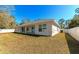 Spacious backyard with a well-maintained lawn and a modern one-story home with white trim at 2155 Jagust Rd, North Port, FL 34288