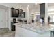 Open kitchen featuring dark cabinetry, stainless appliances, and a marbled countertop island at 2155 Jagust Rd, North Port, FL 34288
