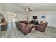 Spacious living room with leather furniture, ceiling fan, and gray tile flooring at 2155 Jagust Rd, North Port, FL 34288
