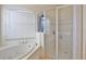 Bright bathroom featuring a soaking tub under a window and a glass-enclosed shower with white tile at 2737 Harvest Dr, Sarasota, FL 34240