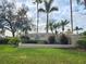 Community entrance sign featuring lush landscaping, palm trees and manicured lawn at 2737 Harvest Dr, Sarasota, FL 34240