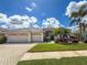 Inviting one-story house with a three-car garage, paver driveway, and vibrant landscaping at 2737 Harvest Dr, Sarasota, FL 34240