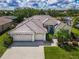 Stunning single-story home featuring a three-car garage, tile roof, and beautifully landscaped front yard at 2737 Harvest Dr, Sarasota, FL 34240