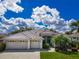 Charming single-story home with a well-manicured lawn, three-car garage, and elegant architectural details at 2737 Harvest Dr, Sarasota, FL 34240