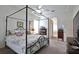 Comfortable main bedroom featuring a four-poster bed, neutral tones, and a glimpse into the ensuite at 2737 Harvest Dr, Sarasota, FL 34240