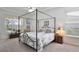 Elegantly furnished main bedroom with a four-poster bed, tray ceiling, and ample natural light at 2737 Harvest Dr, Sarasota, FL 34240